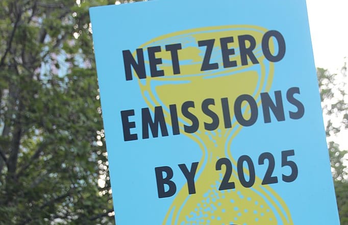 Man holds 'net zero emissions by 2025' sign at Extinction Rebellion Spring Rebellion Melbourne, on Friday 11 October 2019.