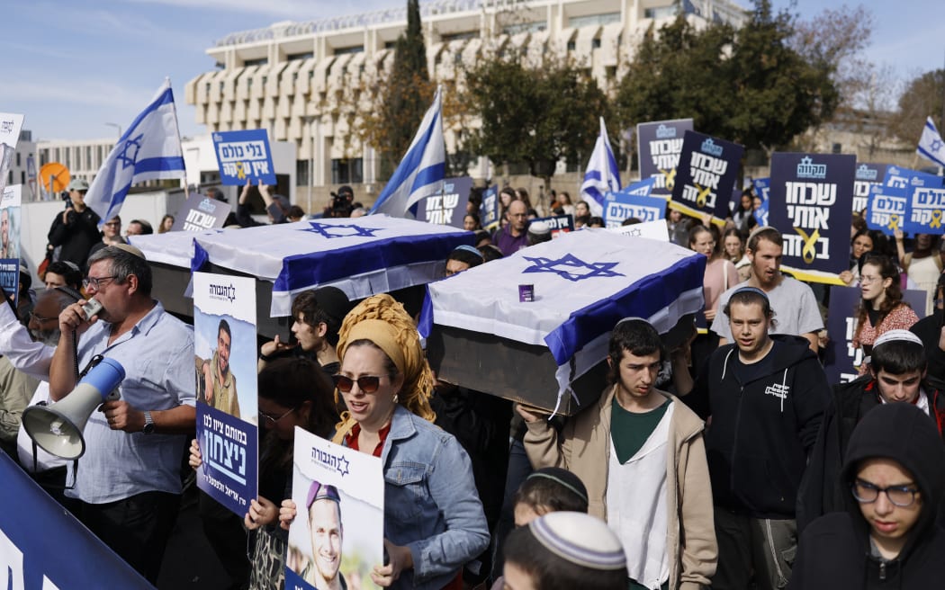 Israeli protesters carry mock coffins draped in the national flag of Israel during a protest against the ceasefire with Hamas outside the Supreme Court in Jerusalem on January 16, 2025. Israel's cabinet was expected to meet on January 16 to approve a ceasefire and hostage-release deal with Hamas, according to Israeli media, a day after mediators announced an agreement they hope will lead to a permanent end to the Gaza war. (Photo by John Wessels / AFP)