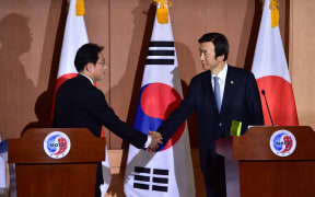 Japan's Foreign Minister Fumio Kishida (L) shakes hands with his South Korean counterpart Yun Byung-Se (R) after a joint press briefing at the Foreign Ministry in Seoul on December 28, 2015.