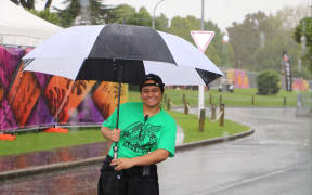 Getting the job done - a Polyfest volunteer who was still smiling as the wind blew and rain poured.