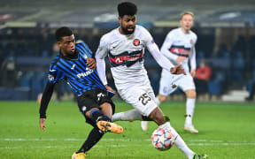 Atalanta's Ivorian forward Amad Diallo (L) shoots on goal while challenged by Midtjylland's Canadian defender Manjrekar James.