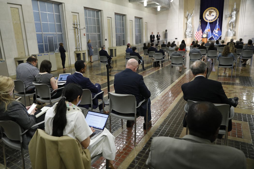 Journalists look on as US Attorney General Merrick Garland speaks at the US Department of Justice in Washington DC.