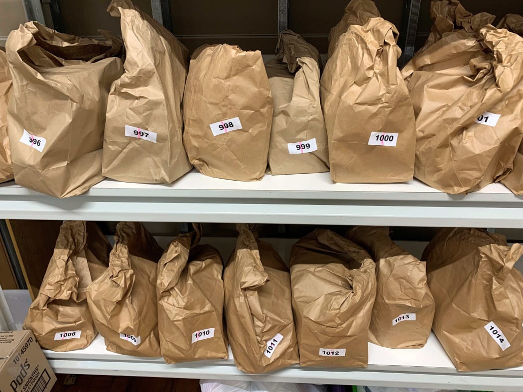 brown paper bags with numbers labels sit on a shelf