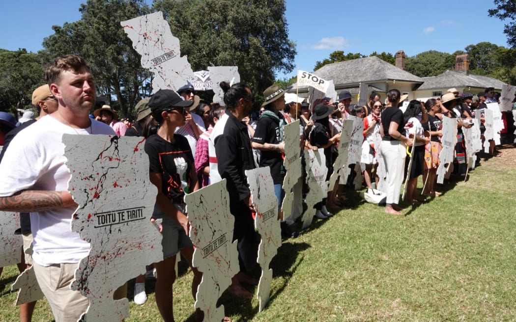 Protesters carrying wooden signs shaped as the Te Tiriti o Waitangi document on 5 February 2024.