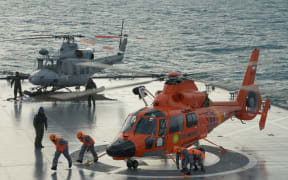 An Indonesian search and rescue helicopter lands on the deck of the Indonesian Navy vessel KRI Banda Aceh as operations to lift the tail of AirAsia flight QZ8501 continue.