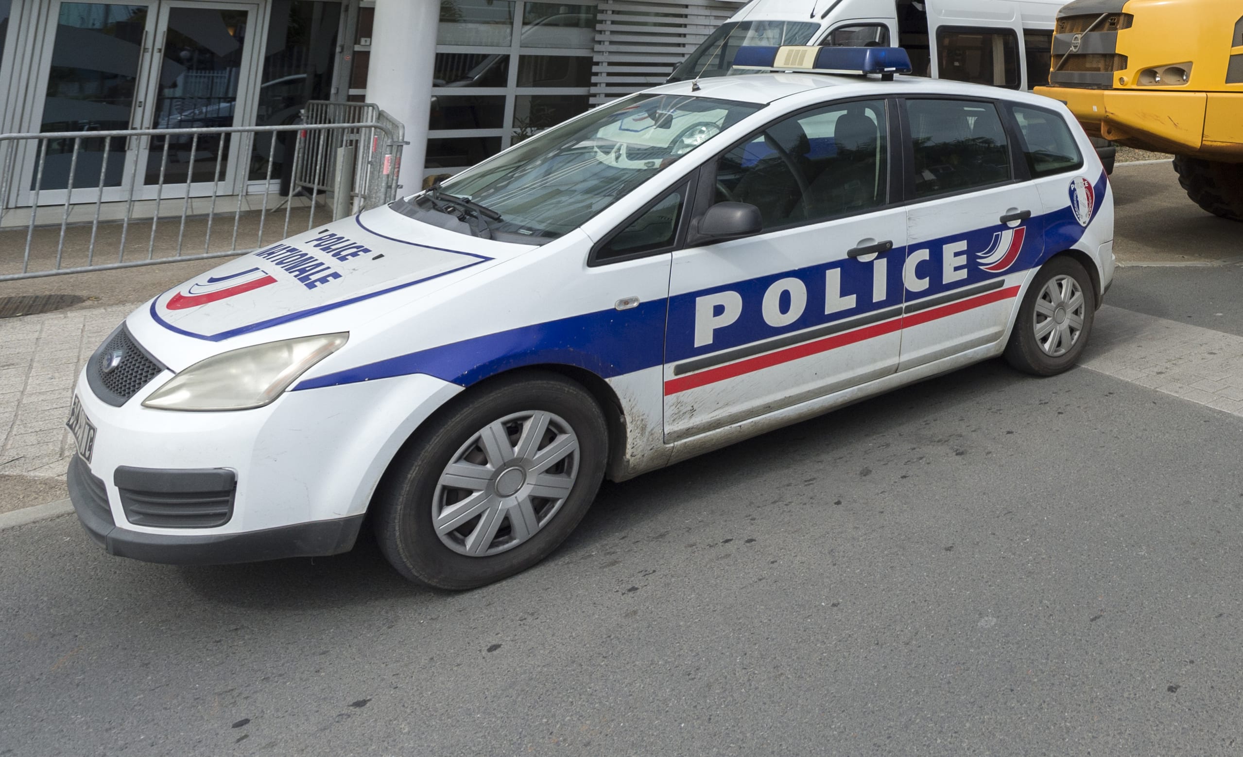 truck is parked behind a police vehicle outside the local government building as part of a protest in Noumea organised by ContraKmine, the union of mining contractors, calling on local authorities to overturn a decision on nickel exports to China on August 5, 2015.