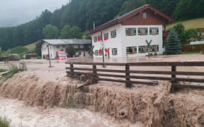 Water flows over a square in front of a house in Bavaria, Germany