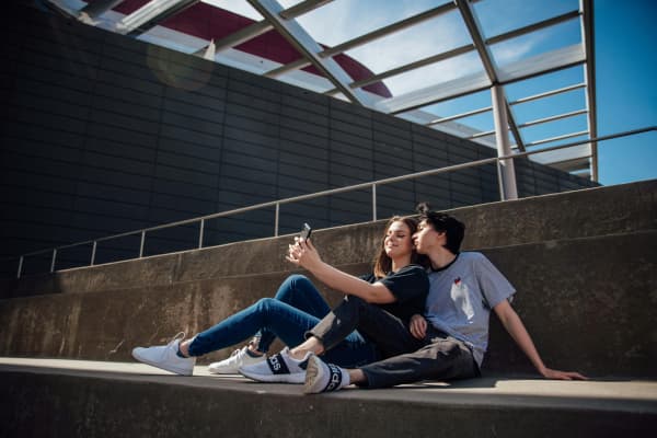 A young couple pose for a selfie in the sun.