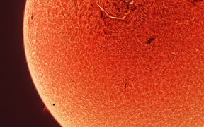 Mercury is only just visible against the sun as a small dark dot on the bottom left of the image.