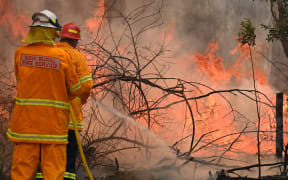 Firefighters tackle a bushfire to save a home in Taree, 350km north of Sydney on 9 November 2019.