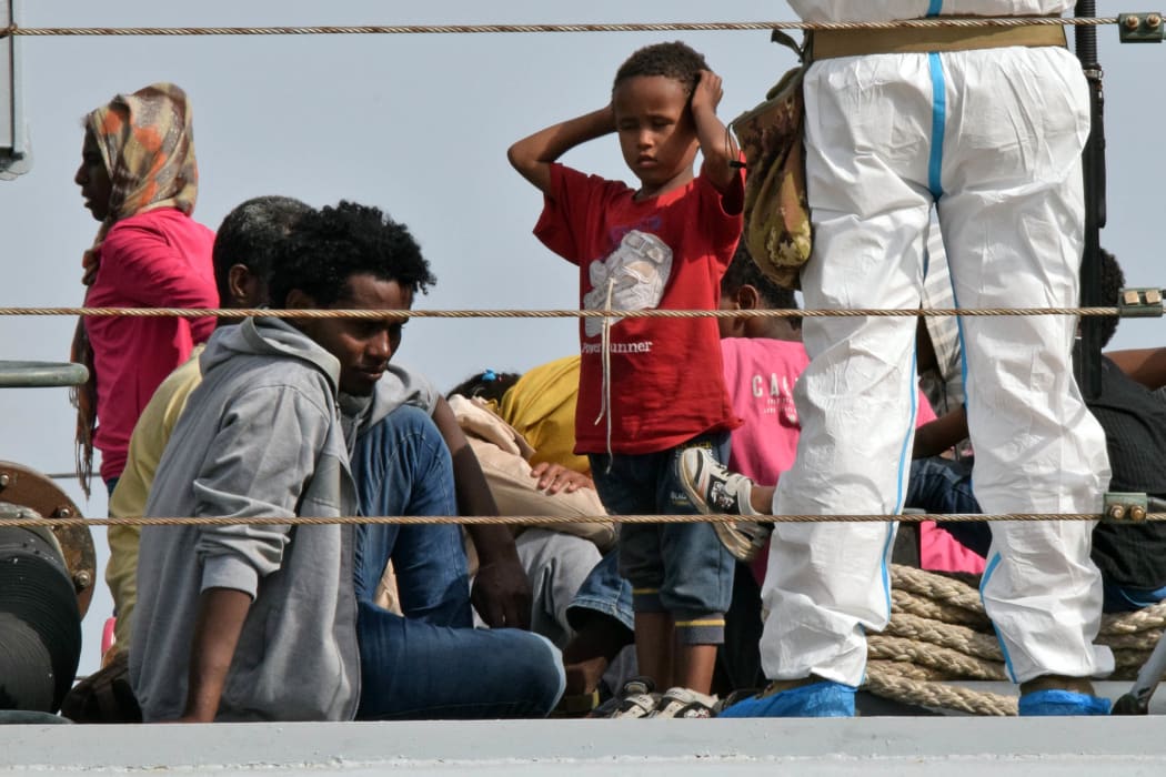 Migrants disembark from an Italian military ship at the port of Augusta, on the eastern coast of Sicily, on 21 May 2015.
