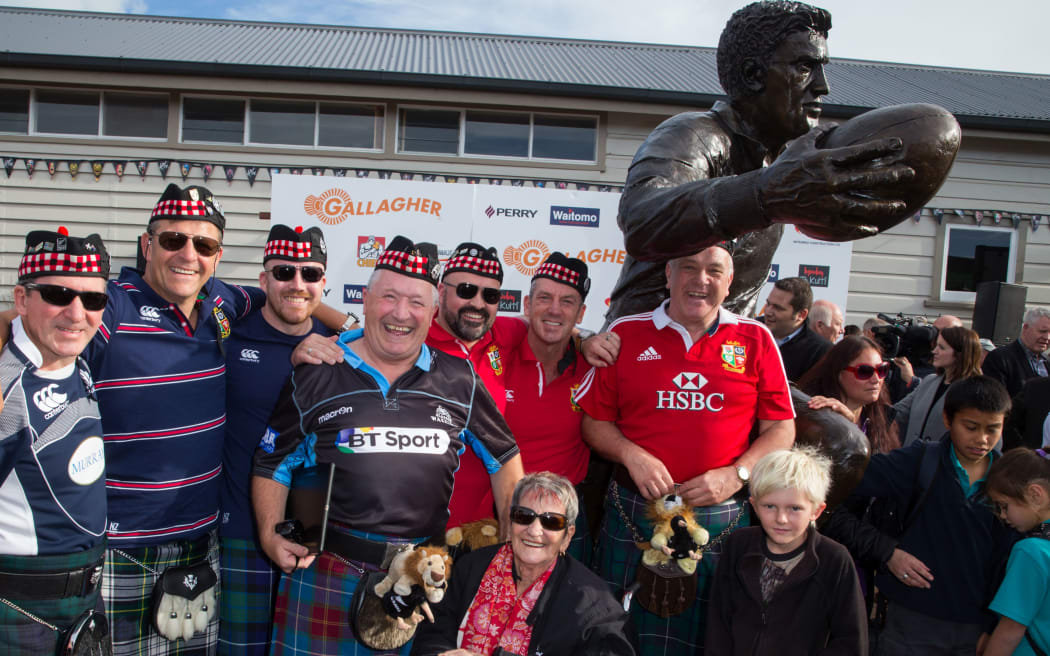 British and Irish Lions fans crowd the statue for a photo at the official unveiling of All Black legend Sir Colin Meads bronze statue, and opening of the Meads brothers exhibition in Te Kuiti.