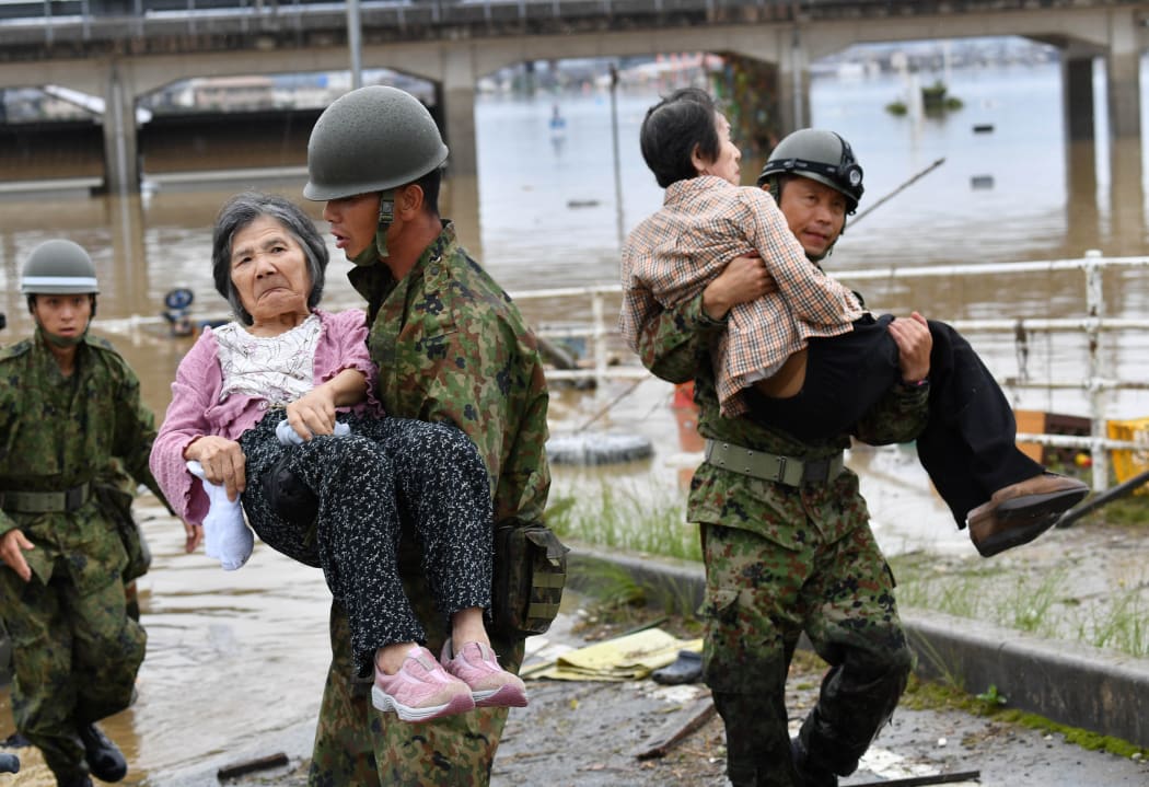 Self-Defense Force personnel carry people rescued from isolated nursing home in Kurashiki, Okayama Prefecture on July 8, 2018