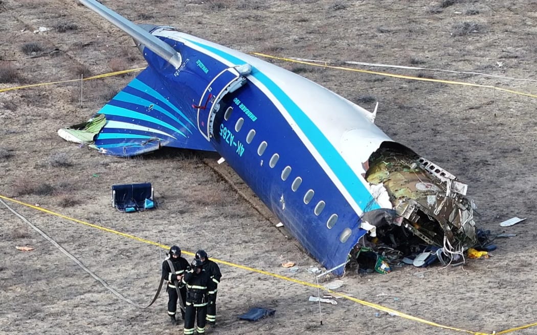 Emergency workers are seen at the crash site of the Azerbaijan Airlines passenger plane near the city of Aktau, Kazakhstan.