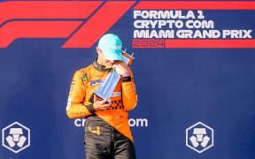 McLaren driver Lando Norris hugs the trophy as he celebrates his win in Miami, 2024.