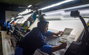 A worker inspects fabric for export before the dyeing process at the Trisula Textile Industries factory in Cimahi, West Java on 15 April, 2025.