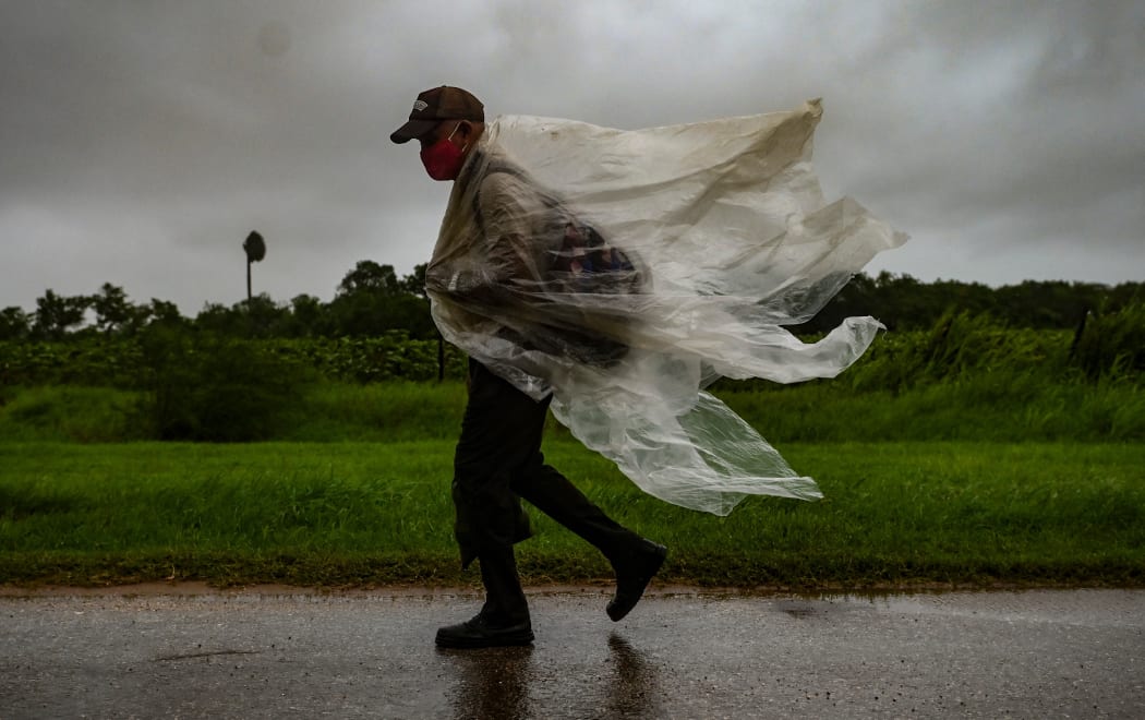 A man walks under the rain in Batabano, Mayabeque province, about 60 km south of Havana, on August 27, 2021, as Hurricane Ida passes through eastern Cuba.