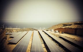 solar plant energy environment production clean modern future electricity with sun and wind mills in the mountains with ocean view. new world with no pollution and carbon