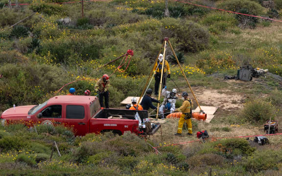 A rescue worker descends into a waterhole where human remains were found near La Bocana Beach in Ensenada, Mexico, on 3 May, 2024.