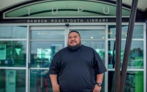 Karl Tusini-Rex standing in front of the Dawson Rd Youth Library.