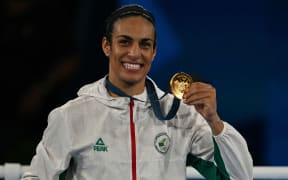 Gold medallist Algeria's Imane Khelif poses on the podium during the medal ceremony for the women's 66kg final boxing category during the Paris 2024 Olympic Games at the Roland-Garros Stadium, in Paris on August 9, 2024. (Photo by Mauro PIMENTEL / AFP)