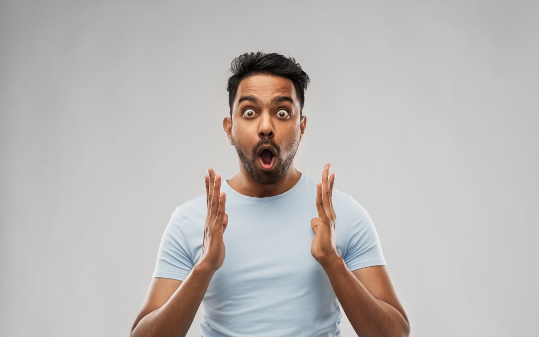 emotion, expression and people concept - scared man in t-shirt over grey background