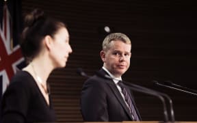 Chris Hipkins looking at Jacinda Ardern