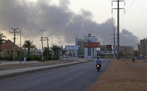 Smoke billows above residential buildings in Khartoum on 16 April 2023, as fighting in Sudan raged for a second day in battles between rival generals.