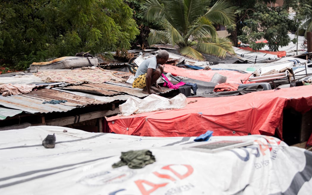 A man arranges his tent in a displaced persons camp that was flooded following Tropical Storm Melissa in Port-au-Prince, Haiti.