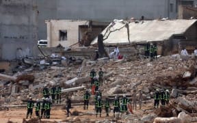 Rescuers gather amid the rubble of buildings damaged or levelled in flash floods after the Mediterranean storm "Daniel" hit Libya's eastern city of Derna, on 14 September, 2023. A global aid effort for Libya gathered pace on September 14 after a tsunami-sized flash flood killed at least 4,000 people, with thousands more missing, a death toll the UN blamed in part on the legacy of years of war and chaos.