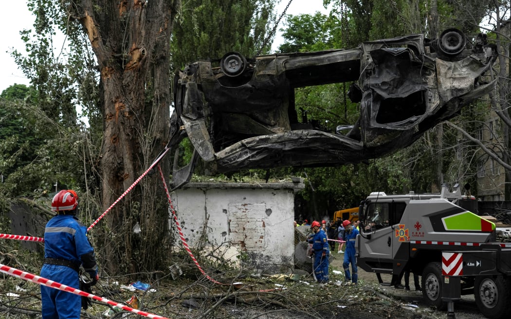Ukrainian rescuers remove a burnt-out car at the site of an air attack in Kyiv on 31 July, 2025, amid the Russian invasion of Ukraine.