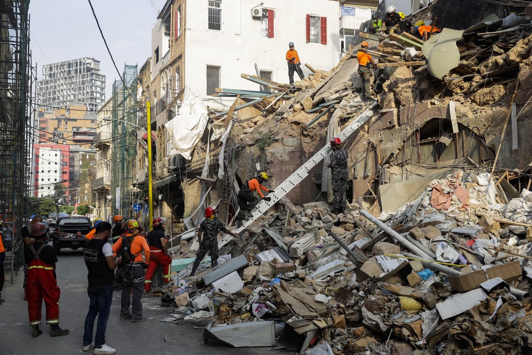 Rescue workers dig through the rubble of a building in Lebanon's capital Beirut in search of possible survivors from a blast at the adjacent port one month ago, after scanners detected a pulse, on September 3, 2020.