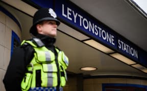 A policeman stands guard at Leytonstone Station