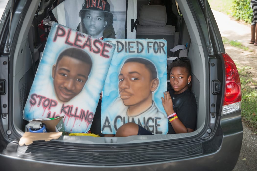 A car leaves the memorial service marking the anniversary of Michael Brown's death.