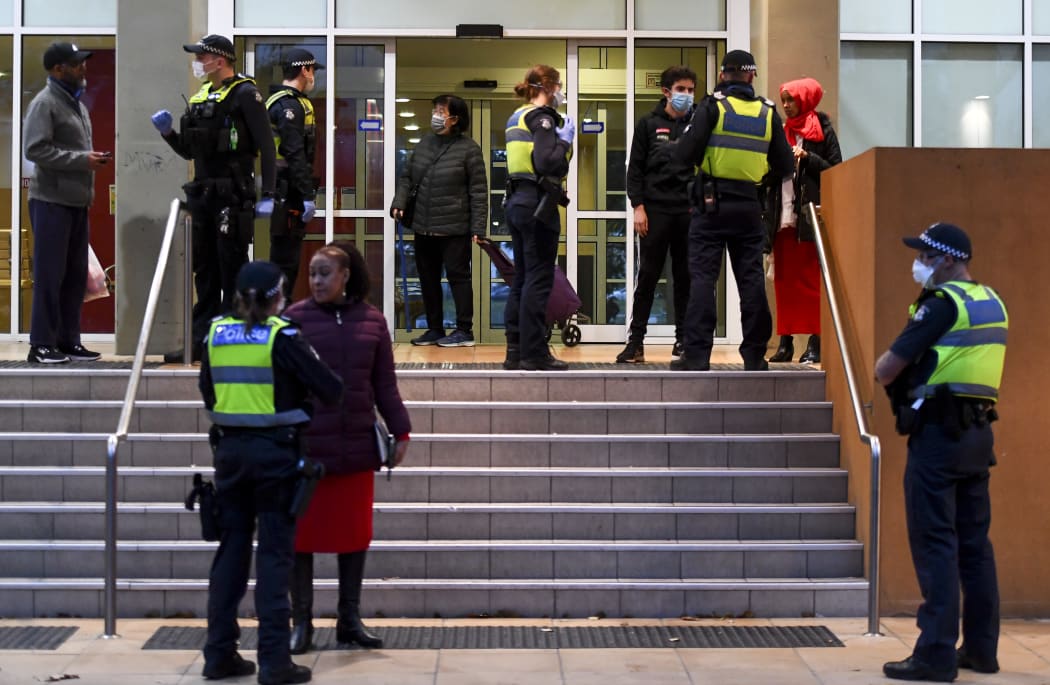Police speak to residents of one of the nine public housing estates locked down in Melbourne.