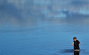 Child playing in rising tide at Motueka estuary
