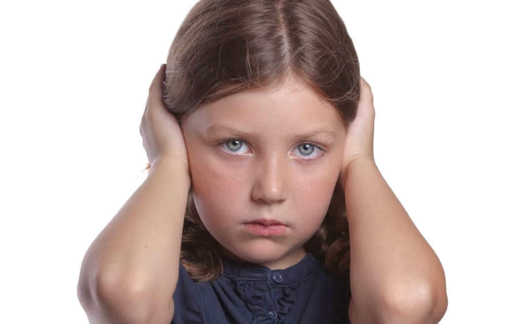 little girl covers ears