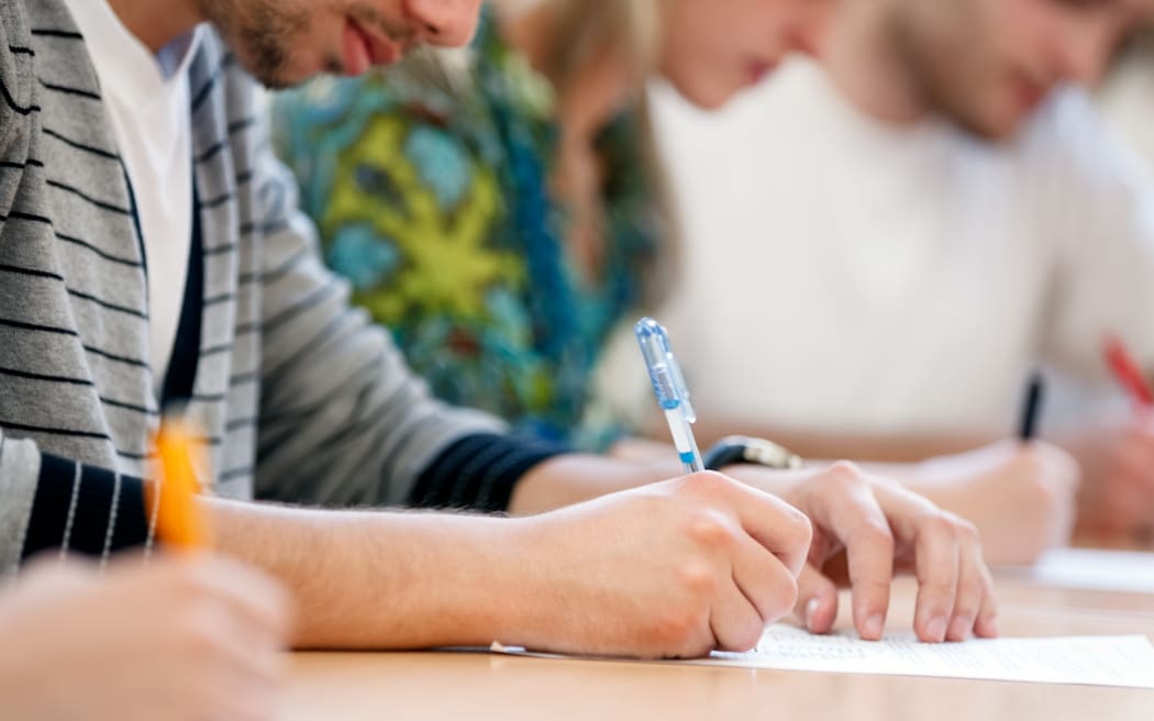 21790139 - writing hands of students at course
