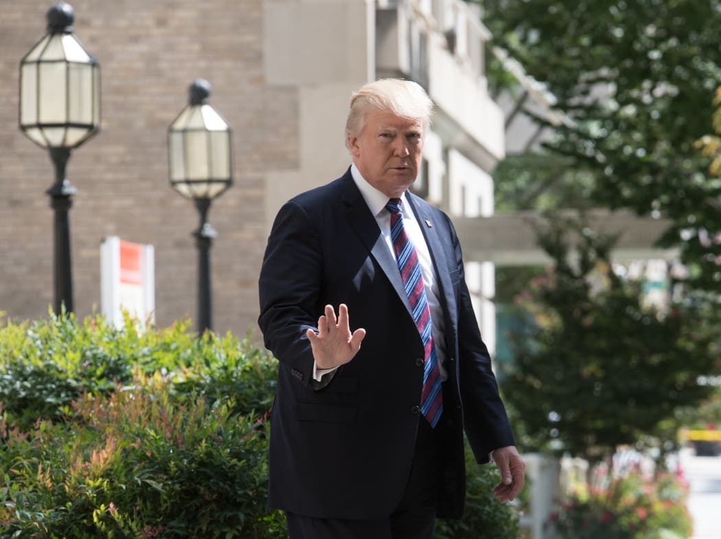 US President Donald Trump waves to the press as he walks out of St John's Epicopal Church in Washington, DC, on 3 September  2017 after attending a service on the National Day of Prayer for victims of Hurricane Harvey.