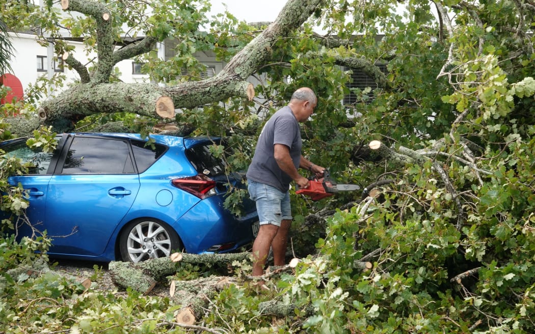 A main using a chainsaw on Moir Street.