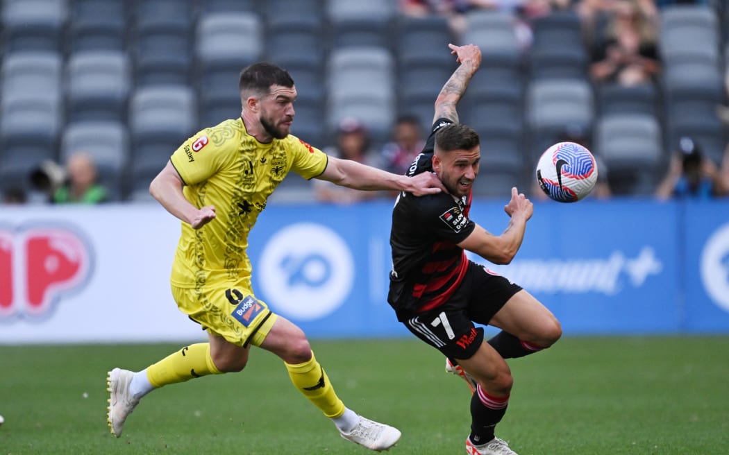 Tim Payne of the Phoenix (L) and Dylan Pierias of the Wanderers compete for the ball during their men's A-League match.
