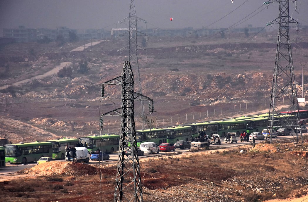 Buses are seen during an evacuation operation of Syrian rebel fighters and civilians from a opposition-held area of Aleppo towards rebel-held territory in the west of Aleppo's province on December 16