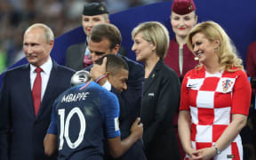French President Emmanuel Macron embraces Kylian Mbappe at the award ceremony, with Russian president Vladimir Putin (left) and Kolinda Grabar-Kitarović, President of Croatia (right)