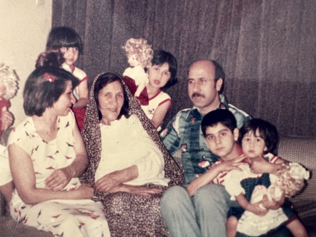 Marjan (in the blue dress) 3 years old in Iran. Alongside her mum, dad, and ‘Aba’, her sisters and cousins.