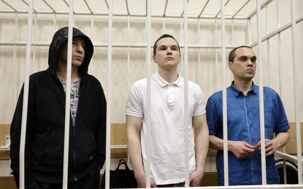 The three lawyers who used to represent the late opposition leader Alexei Navalny: Igor Sergunin, Alexei Liptser and Vadim Kobzev (L-R in the defendants' cage), accused of participating in an "extremist" organisation, attend their verdicts reading in the town of Petushki in the Vladimir region on January 17, 2025. (Photo by TATYANA MAKEYEVA / AFP)