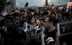Benny Tai (right), co-founder of the Occupy Central movement, talks to the media at a rally near the Hong Kong government complex.