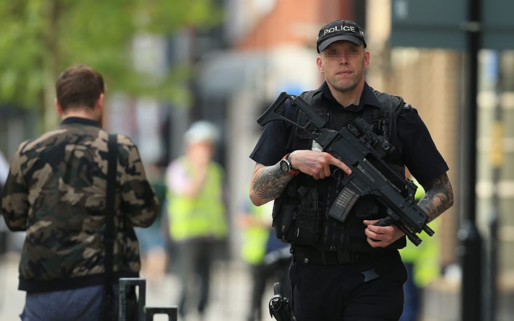 An armed police officer patrols the streets of Manchester.
