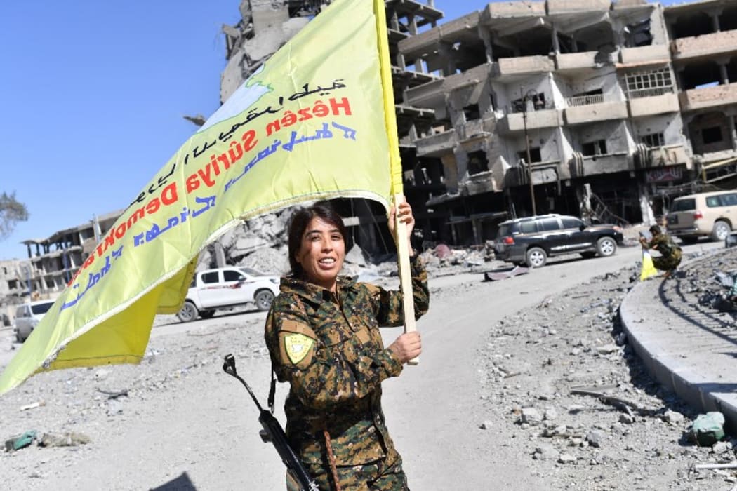 Rojda Felat, a Syrian Democratic Forces (SDF) commander, waves her group's flag at the iconic Al-Naim square in Raqa.