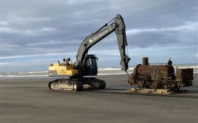 The Skunk locomotive being lifted out of the sand near Whanganui Port.
