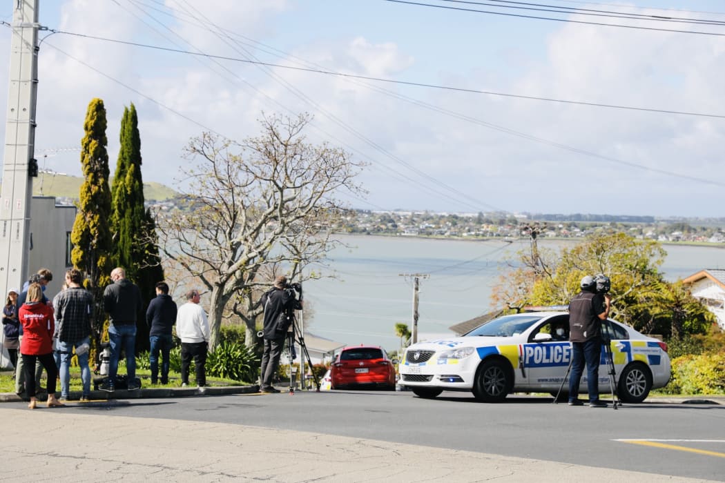Police and onlookers at Hillsborough, Auckland, after a person in possession of a firearm was shot by police and is in a serious condition following a chase that ended on Lilac Grove.